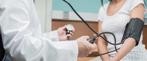 доктор измеряет артериальное давление пациента после запоя